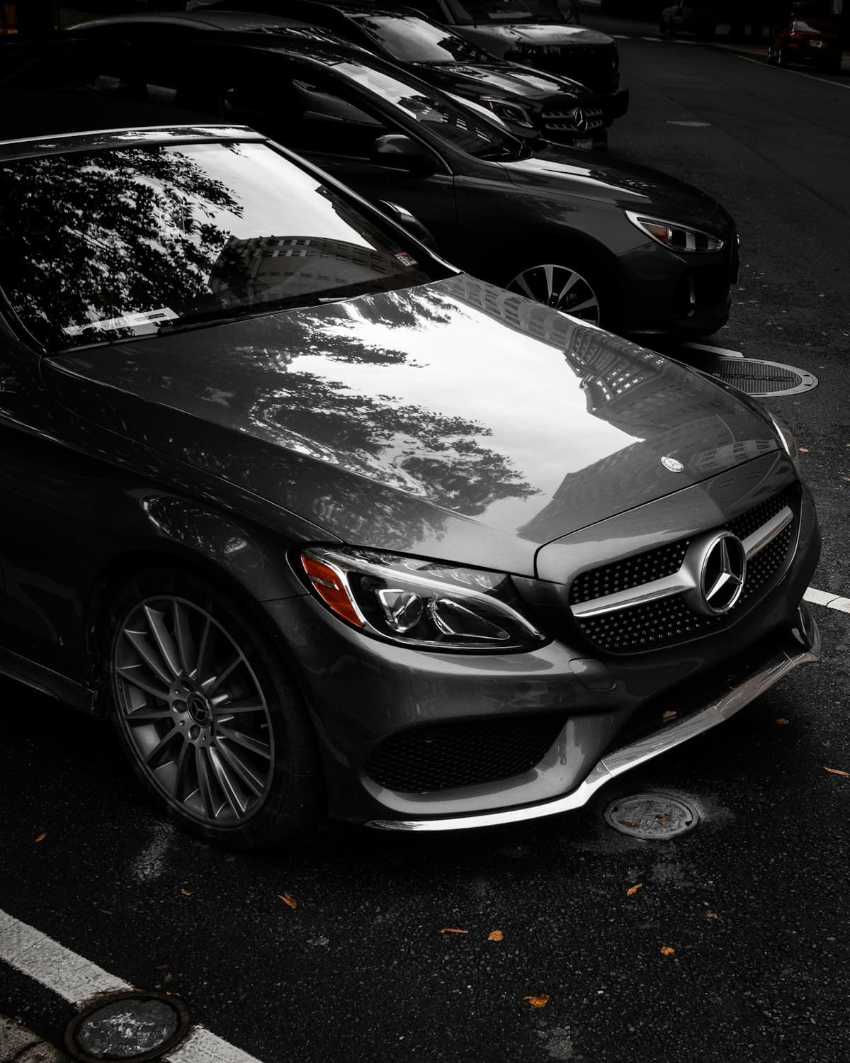 Silver Mercedes-Benz C-Class parked under trees