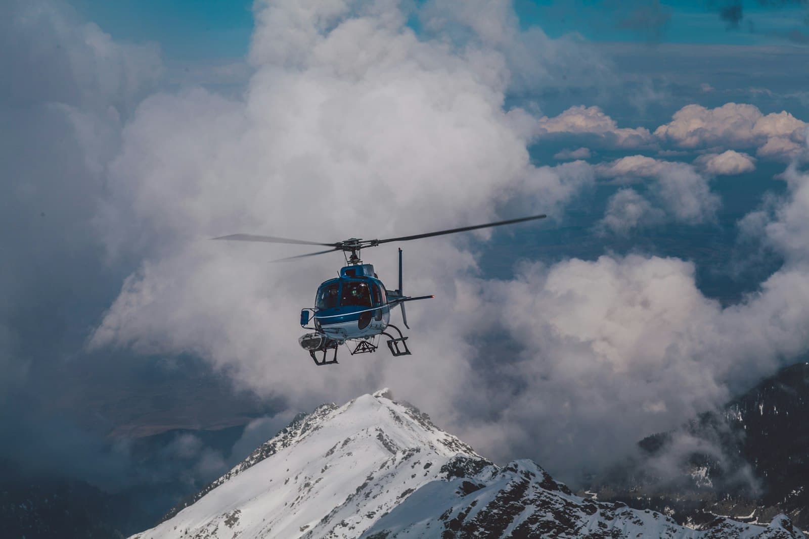 Helicopter flying above snow-capped mountains