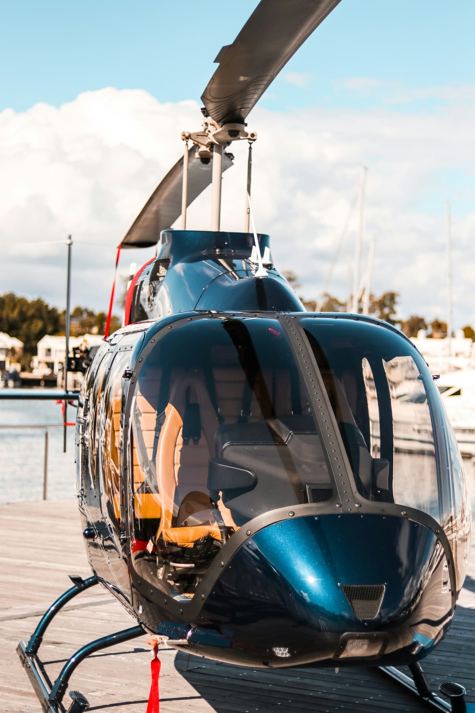 Glossy executive helicopter on a waterfront pad